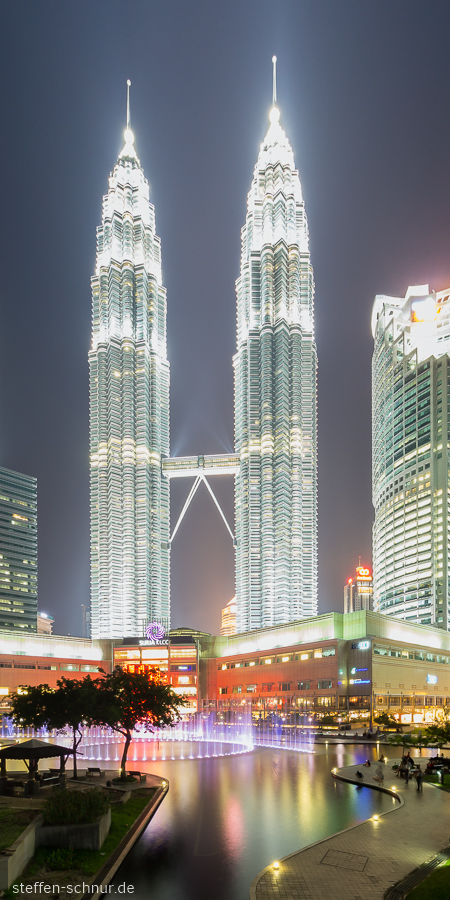 Petronas Towers
 Kuala Lumpur
 Malaysia
 tree
 fountain
 lights
 night
