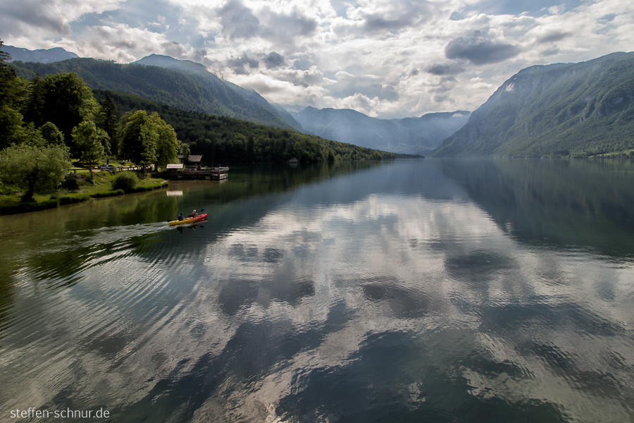 mountains
 lake Wochein
 Slovenia
 canoe
 reflections
 lake
 clouds

