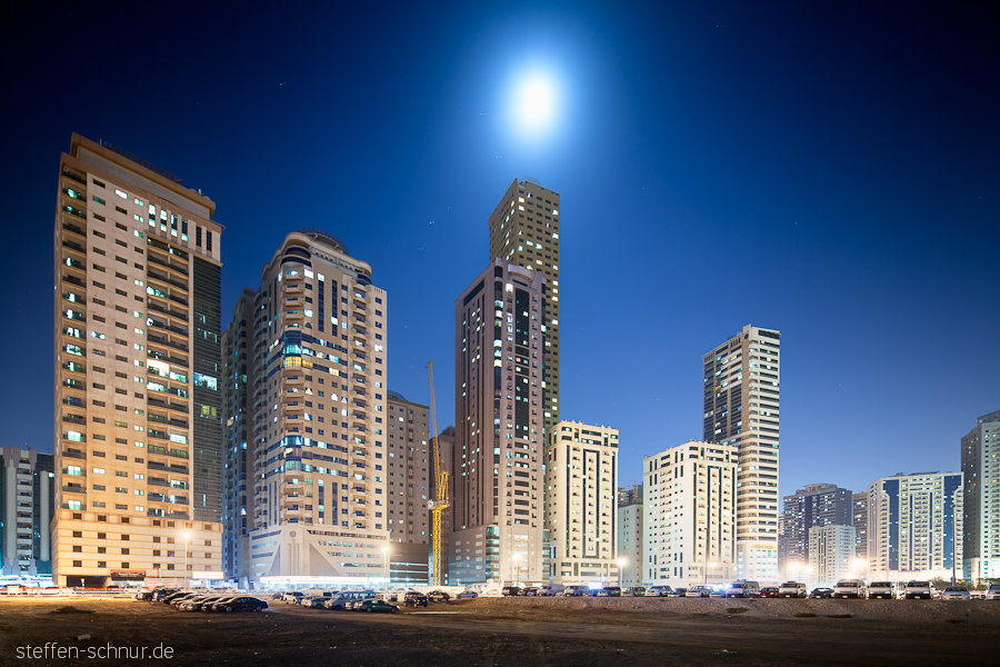cars
 moon
 Sharjah
 crane
 skyscrapers
 parking
 stars

